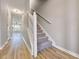 Hallway with hardwood flooring leading to a staircase and a living area with a fan at 7229 Georges Way, Morrow, GA 30260