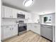 Bright kitchen with stainless appliances, white cabinets, backsplash and light countertop, plus wood-look vinyl flooring at 7229 Georges Way, Morrow, GA 30260