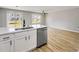 Modern kitchen featuring a stainless steel dishwasher, a quartz countertop island, and hardwood floors at 7229 Georges Way, Morrow, GA 30260