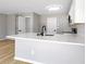 Bright kitchen features a breakfast bar with light countertop, undermount sink with black faucet, and tiled backsplash at 7229 Georges Way, Morrow, GA 30260