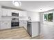 Bright kitchen with stainless appliances, white cabinets and light countertop, plus sliding doors leading to the yard at 7229 Georges Way, Morrow, GA 30260