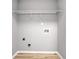 Clean, empty laundry room ready for washer and dryer hookups with wood-look floors at 7229 Georges Way, Morrow, GA 30260