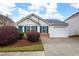 Charming home featuring a well-maintained front yard with flowering bushes and an attached garage at 115 Oak Grove Pl, Acworth, GA 30102