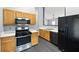 Kitchen featuring stainless steel appliances, light wood cabinetry, and modern fixtures at 115 Oak Grove Pl, Acworth, GA 30102