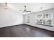 Bright living room featuring dark wood flooring, a modern ceiling fan, and large windows at 115 Oak Grove Pl, Acworth, GA 30102