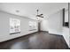 Sunlit living area featuring modern flooring, a ceiling fan, and multiple windows at 115 Oak Grove Pl, Acworth, GA 30102