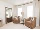 Comfortable bedroom seating area with two armchairs, side table, and large mirror, illuminated by natural light at 2698 Ne Almand Ne Ln, Conyers, GA 30013