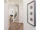 Inviting hallway with wood floors, a staircase, decorative art, and a glimpse of the living room at 2698 Ne Almand Ne Ln, Conyers, GA 30013