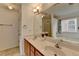 Bright bathroom featuring double sinks, wood cabinets, and a large mirror, offering ample space and natural light at 3517 Harvest Ridge Ln, Buford, GA 30519