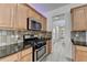 Kitchen features a stainless steel stove, granite countertop, and mosaic tile backsplash at 3517 Harvest Ridge Ln, Buford, GA 30519