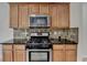 Kitchen features stainless steel appliances, mosaic backsplash, and wooden cabinets at 3517 Harvest Ridge Ln, Buford, GA 30519
