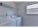 Cozy laundry room with white appliances, shelving and natural light from a window at 3517 Harvest Ridge Ln, Buford, GA 30519