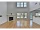 Spacious living area with fireplace, hardwood floors, and a high ceiling with large windows filling the room with light at 3517 Harvest Ridge Ln, Buford, GA 30519