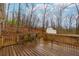 View of the wooden back deck overlooking the wooded backyard with a storage shed at 67 Red Top Cir, Emerson, GA 30137