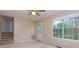 Living room with neutral carpet, large windows, ceiling fan, and an entryway leading to the stairwell at 67 Red Top Cir, Emerson, GA 30137