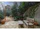 Serene backyard retreat with stone patio, mature trees, and tranquil seating area, perfect for relaxation at 2005 Westbourne Way, Alpharetta, GA 30022