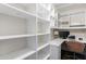 Bright closet area, with built in shelves, that is also a workspace with a built-in desk and office chair at 2005 Westbourne Way, Alpharetta, GA 30022