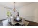 Formal dining room with wainscoting, a crystal chandelier, and views of the front yard at 2005 Westbourne Way, Alpharetta, GA 30022