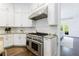 Modern kitchen featuring white cabinetry, granite countertops, stainless steel appliances, and hardwood floors at 2005 Westbourne Way, Alpharetta, GA 30022