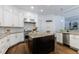 Gourmet kitchen featuring white cabinetry, granite countertops, stainless steel appliances, and a contrasting dark wood island at 2005 Westbourne Way, Alpharetta, GA 30022
