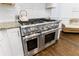 Modern kitchen showcasing a stainless steel range, white cabinets, granite countertops, and hardwood floors at 2005 Westbourne Way, Alpharetta, GA 30022