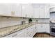 Close-up of a kitchen featuring white cabinets, granite countertops, stainless steel appliances, and subway tile backsplash at 2005 Westbourne Way, Alpharetta, GA 30022