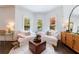 Sunlit living room with white sofas, hardwood floors, and views of the landscaped backyard at 2005 Westbourne Way, Alpharetta, GA 30022