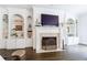 Living room features built-in shelving, fireplace, mounted TV, dark wood floors and detailed trim at 2005 Westbourne Way, Alpharetta, GA 30022