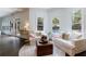 Bright living room with hardwood floors and large windows provides a view of the outdoor swimming pool at 2005 Westbourne Way, Alpharetta, GA 30022