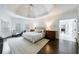 Bright primary bedroom with tray ceiling, hardwood floors, and elegant furnishings at 2005 Westbourne Way, Alpharetta, GA 30022