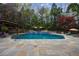 Serene in-ground swimming pool surrounded by lush landscaping and a stone patio at 2005 Westbourne Way, Alpharetta, GA 30022