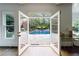 Interior view through French doors of a serene pool and patio, creating a seamless indoor-outdoor living experience at 2005 Westbourne Way, Alpharetta, GA 30022
