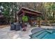 Inviting poolside patio area with an outdoor dining table and comfortable seating under a charming pergola at 2005 Westbourne Way, Alpharetta, GA 30022