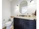 Stylish powder room featuring dark cabinetry, granite countertop, decorative mirror, and updated fixtures at 2005 Westbourne Way, Alpharetta, GA 30022