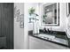 Stylish bathroom showcasing illuminated mirror, dark countertop, and unique wall art at 3120 Godby Rd # 1118, Atlanta, GA 30349