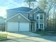 Charming two-story home with a two-car garage and manicured lawn at 4578 Carriage Park Dr, Lithonia, GA 30038