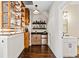 Chic bar area featuring open shelving, wine storage, a mini fridge, and hardwood floors at 561 S Club Dr, Woodstock, GA 30188
