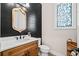 Chic powder room featuring a wood vanity, decorative mirror, and patterned floor tiles at 561 S Club Dr, Woodstock, GA 30188