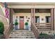 Inviting front porch with stone stairs, decorative lanterns, sunburst decor, and lush ferns, creating a warm welcome at 561 S Club Dr, Woodstock, GA 30188