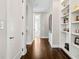 Hallway with hardwood floors, built in shelves, white trim, and grey walls at 561 S Club Dr, Woodstock, GA 30188