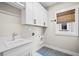 Bright laundry room with white cabinetry and quartz countertop sink at 561 S Club Dr, Woodstock, GA 30188