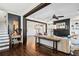 Open living room features hardwood floors, dark wood beams, fireplace, creating a cozy and inviting space at 561 S Club Dr, Woodstock, GA 30188
