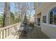 Outdoor deck area with stylish metal table and chairs overlooking wooded backyard, striped umbrella at 1201 Lake Washington Dr, Lawrenceville, GA 30043