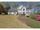 Charming two-story home with black shutters and beautifully landscaped front yard and blooming azaleas at 1201 Lake Washington Dr, Lawrenceville, GA 30043