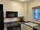 Functional kitchen featuring white cabinets and black appliances, including a microwave and stove at 300 Peachtree Ne St # 9A, Atlanta, GA 30308