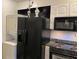 Efficient kitchen featuring black appliances, stacked washer/dryer, and white cabinetry at 300 Peachtree Ne St # 9A, Atlanta, GA 30308
