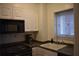 Functional kitchen featuring white cabinets and black appliances, including a microwave and stove at 300 Peachtree Ne St # 9A, Atlanta, GA 30308