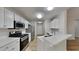 Modern kitchen featuring stainless steel appliances, white cabinets, quartz countertops, and open layout at 3035 Sherbourne Dr, Lithonia, GA 30058