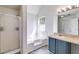 This bathroom features a soaking tub, shower, and a blue vanity with a granite countertop at 4542 White Rd, Douglasville, GA 30135