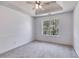 This bedroom features fresh paint, plush carpet, a ceiling fan, and a window that provides views of the surrounding greenery at 4542 White Rd, Douglasville, GA 30135